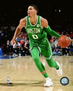 an autographed photo of boston basketball player dribbling the ball in front of fans