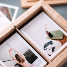 an open box with photos inside on a table next to other pictures and wooden frames