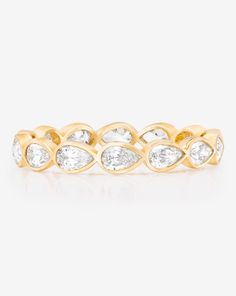 a yellow gold ring with pear shaped diamonds on the sides and an oval design in the middle