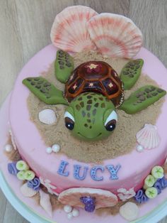 there is a cake decorated with a turtle and seashells on the bottom layer