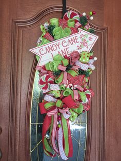 a candy cane christmas wreath hanging on the front door for someone's holiday decor