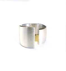 This fabulous wide minimalist ring is hand made in Sterling Silver and 18ct Yellow Gold. The widest side is 19mm from top to bottom and the narrower side is approx 11mm from top to bottom, tapering down to approximately 12mm at the back of the ring. The rectangle in the centre is shiny. The silver band has a satin or Florentine finish, and the edges of the ring are shiny. Made to last, this solid ring can be worn day-in, day-out and will look great with gold and silver jewellery, it's great to m Modern Wide Band Anniversary Rings, Modern Wide Band Ring For Anniversary, Modern White Gold Dome Ring With Open Band, Modern Wide Band Jewelry For Anniversary, Modern Open Band Wide Ring For Formal Occasions, Modern Wide Band Open Ring For Formal Occasions, Modern Dome Ring With Open Band, Modern White Gold Rings With Wide Band, Modern Signet Ring With Polished Finish And Open Band