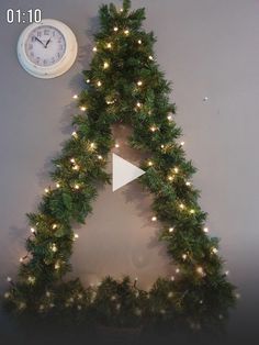 a christmas tree with lights and a clock on the wall