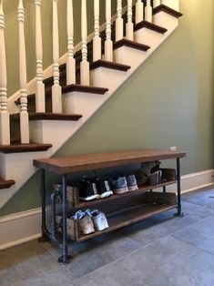 a wooden shoe rack under a stair case