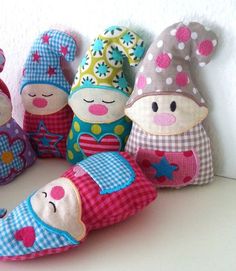 several small stuffed animals sitting next to each other on a white surface with pink and blue polka dots