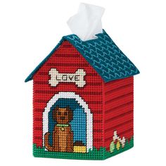 a red dog house with a bone on it's roof and a tissue dispenser