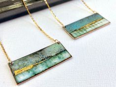 "Rectangle enamel pendant - Landscape inspired These stunning rectangle pendants have been handmade using copper, vitreous enamel and 24ct gold foil available in blue or green. To create the impression of a landscape layers of vitreous enamel have been used to build up the depth and variation in colour and then finished with gold foil. Each pendant measures 40mm x 15mm 18\" Gold plated sterling silver chain NOTE: Due to the way in which the enamel is applied there will be colour variation and no one piece will be exactly the same, and may vary from the image shown.  This makes each piece unique to you.  I am more than happy to email you a photo of your item before I post if if this is a concern." Red Statement Earrings, Silver Round Earrings, Rectangle Necklace, Enamel Stud Earrings, Vitreous Enamel, Enamel Necklaces, Bib Necklaces, Colorful Jewelry, Enamel Earrings