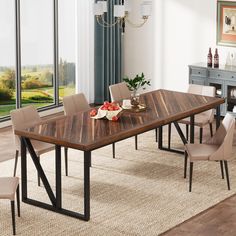 a dining room table with chairs and a bowl of fruit on the table next to it