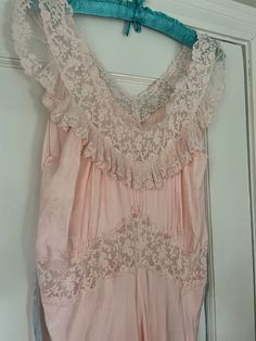 Beautiful 1940s 1950s Lady Leonora pink lacy peignoir nightgown. Color is a pale pink with periwinkle ties. Made of Rayon. Please read measurements: 57" long 32" waist 32" underarm 40" hip *Clothing items are not returnable. Please read the descriptions carefully and message me with any questions before purchasing. Please don't hesitate to message me with any questions you may have. I'll happily combine shipping on multiple items. Be sure to check out my other listings. Thanks for looking! Vintage Nightgown With Delicate Lace For Wedding Night, Feminine Pink Sleepwear With Delicate Lace, Vintage Pink Sleepwear, Pink Delicate Lace Wedding Night Sleepwear, Vintage Pink Sleeveless Nightgown, Pink Sleeveless Vintage Nightgown, Vintage Wedding Sleepwear With Lace Trim, Vintage Pink Sleepwear For Wedding, Vintage Lace Sleepwear For Bedtime