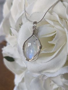 This is a dainty little moonstone' pendant wrapped in sterling silver wire on a snake chain. Delicate Silver Moonstone Ring For Gift, White Sterling Silver Wire Wrapped Jewelry, Dainty Wire Wrapped Moonstone Jewelry, Silver Hand Wrapped Round Pendant Jewelry, White Moonstone Oval Pendant Jewelry, Moonstone Oval Pendant Birthstone Jewelry, Minimalist Wire Wrapped Moonstone Jewelry, Moonstone Birthstone Oval Pendant, White Moonstone Oval Pendant