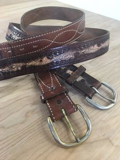 Vintage brown leather belts, one with crisscrossed detailed decorative stitching - marked Tony Lama and the other is 2 toned tooled leather.tooled 2 tone size - 31" - 35"stitched - 29" - 33"Measure yourself with a pair of pants on that you would use with the belt.  For exact measurements, run the tape measure through the belt loops, then compare to above measurements to see if belt will fit.  No refunds on belts.They show the wear of the buckle on some of the holes, but they have many many years