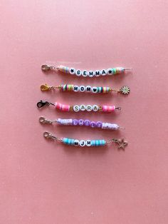 four different colored beads with the word grandma on them are arranged in a row against a pink background