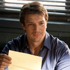 a man sitting at a table holding a piece of paper