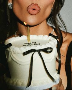 a woman blowing out a candle on her birthday cake with the words happy birthday written on it