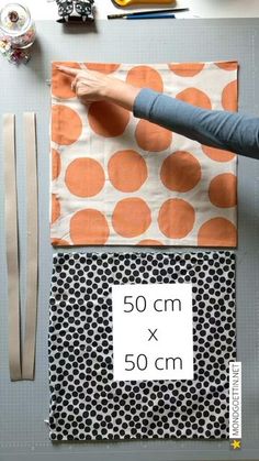 a woman is working on fabric with scissors and sewing supplies next to her workbench