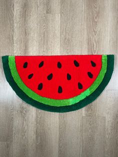 a watermelon rug is on the floor next to a wood flooring board