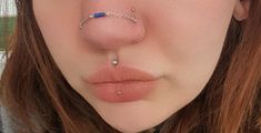 a close up of a person with a nose ring and piercing on it's nose