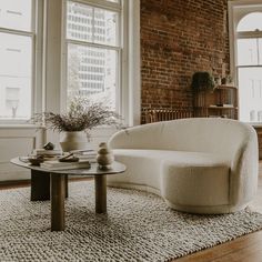 a living room filled with furniture and a brick wall in the backround area