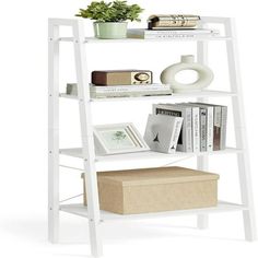 a white shelf with books and plants on top