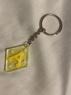 a glass keychain with a yellow giraffe on it's side