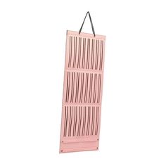 a pink door hanging from the side of a white wall with black lines on it