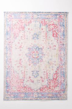 a blue, yellow and pink area rug with an ornate design on the bottom corner