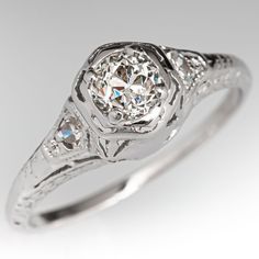 an antique style diamond ring with filigree accents