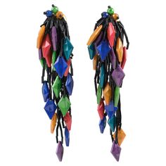 These stunning 1980s dangling Lucite and glass clip-on earrings feature an oversized shoulder-duster design with a waterfall shape comprised of tiny black glass stick beads complimented with diamond-shaped Lucite beads in cobalt blue, olive green, turquoise blue, purple, yellow copper, and red sienna colors with a pearlized pattern. There is no visible maker's mark. Measurements: 2 in wide (5 cm) x 5.32 in long (13.5 cm). Flower Power Fashion, Long Statement Earrings, Geode Jewelry, Art Deco Earrings, Pearl Earrings Dangle, Antique Earrings, Gold Earrings Dangle, Clip Earrings, Sterling Silver Studs