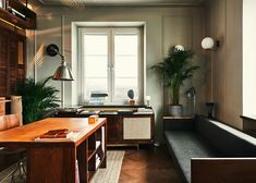 a living room filled with furniture next to a window covered in plants and potted plants