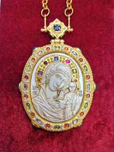 an ornate gold locke with a woman holding a child in it's lapel