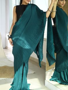 This is a two-piece teal fringe saree set from the Aaryaa by KK collection. This gorgeous teal green fringe saree is paired with a black fringe blouse. The teal green color with crepe, satin fabric cutdana, sequin embroidery and tassels enhance this saree set. The blouse has a boat neckline with fringe feature. The saree is pleated and pre-stitched with embellishments. Green Bollywood Sets With Tassels, Bollywood Green Sets With Tassels, Green Blouse Piece With Dupatta For Evening, Green Saree With Dupatta For Evening, Green Evening Saree With Dupatta, Green Evening Dupatta, Green Bollywood Dupatta With Tassels, Diwali Pre-draped Saree With Tassels, Green Saree With Black Blouse