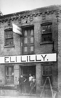 an old black and white photo of people standing in front of a building with the word silly on it