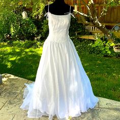 a white wedding dress is on display outside