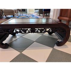 a coffee table sitting on top of a checkered floor