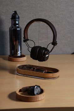 headphones are sitting on a table next to a water bottle and cellphone holder