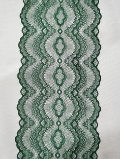 green lace on white fabric with an intricate design