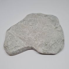 a rock that looks like it is made out of cement and has been placed on a white surface