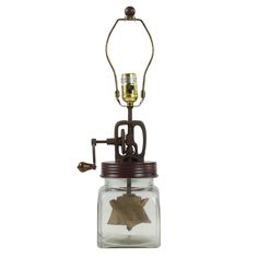 a glass jar with a metal hook and a candle holder on the top that has a leaf in it