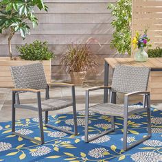 two chairs sitting on top of a blue and yellow rug next to a wooden table