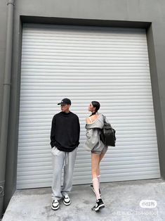 two people standing in front of a garage door