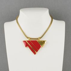 Lovely Lanvin Paris modernist pendant choker necklace. Serpentine gilt metal chain ornates with geometric pendant in shiny gilt metal and red enamel. Spring ring-closing clasp. Signed with a little gilded tag underside the pendant: "Lanvin - Paris." Measurements: total length 15.38 in (39 cm) - pendant: 2.88 in wide x 2.38 in high (7.3 x 6 cm).  Please see the measurements noted above, in the description for the best approximate dimensions. Formal Red Enamel Necklaces, Red Metal Necklace With Large Pendant, Formal Red Enamel Necklace, Modern Gold Enamel Jewelry, Red Enamel Jewelry With Large Pendant, Modern Gold Collectible Jewelry, Formal Red Necklace With Large Pendant, Modern Gold Jewelry For Collectors, Red Necklace With Large Pendant For Formal Occasions