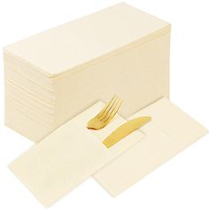 a stack of folded napkins with a fork and knife next to it on a white surface