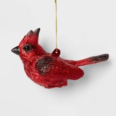 a red bird ornament hanging from a gold chain