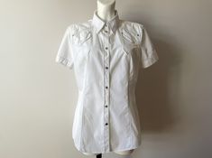 Vintage White summer cotton top, short sleeve women's blouse, denim style shirt, bohemian snap button up top, summer days shirt Label size: UK 16 / US 12 /  Measurements: Shoulders: 16.5 in Pit to pit: 21 in Length: 28 in Sleeve: 7.5 in Material: cotton Please check measurements to insure a proper fit. Remember to allow yourself some extra room for movement. You can compare these with something from your closet that fits you well. Please convo me if you need additional measurements. This blouse Bohemian Short Sleeve Shirt, Fitted Summer Shirt With Button Closure, Bohemian Summer Shirt With Button Closure, Bohemian Shirt With Button Closure For Summer, Fitted Short Sleeve Shirt With Buttons For Summer, Cotton Short Sleeve Blouse With Pockets, Cotton Summer Blouse With Buttons, Cotton Blouse With Pockets And Short Sleeves, Cotton Blouse With Short Sleeves And Pockets