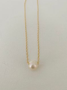 Just A Pearl! This simple yet elegant necklace is part of my Just A Pearl collection. One single pearl dangles from a delicate gold necklace. It measures 16 inches and length and can be adjusted to 15 inches for choker length. Classic Gold Charm Necklace With Pearl Drop, Minimalist Pearl Drop Necklace With Pearl Chain, Minimalist Pearl Chain Necklace With Pearl Charm, Classic Pearl Necklace With Delicate Chain, Classic Gold Charm Necklace With Pearl Chain, Classic Gold Pearl Chain Charm Necklaces, Gold Minimalist Charm Necklace With Pearl Chain, Gold Minimalist Charm Necklaces With Pearl Chain, Minimalist Gold Charm Necklace With Pearl Chain