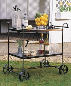 an outdoor bar cart with bottles and glasses on it