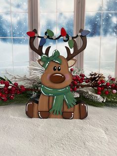 a wooden reindeer sitting in front of a window with christmas lights on it's antlers