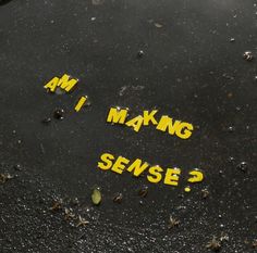 some yellow stickers on the ground that say, i am making sense? and are written in black ink