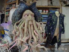 an octopus statue in a room with other items on the shelves and behind it is a mannequin's head