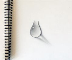 a spiral notebook with a drawing of a water drop on the cover, next to a pen